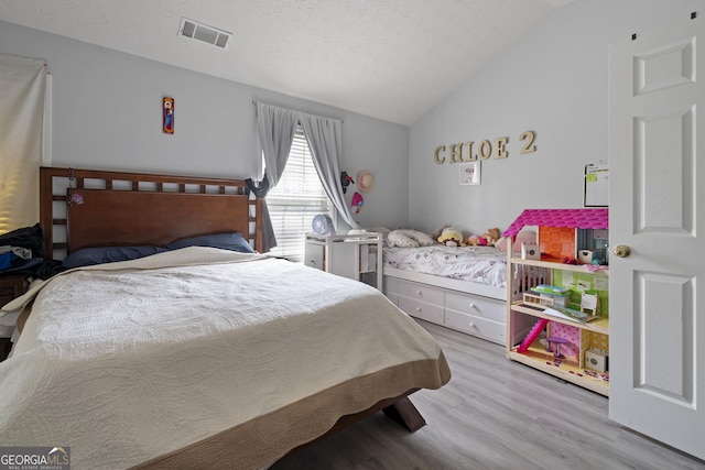 85 Clairidge Ln, Lawrenceville, GA 30046 - bedroom featuring a textured ceiling, visible vents, wood finished floors, and vaulted ceiling