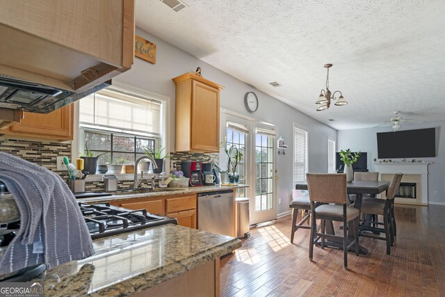 85 Clairidge Ln, Lawrenceville, GA 30046 - kitchen featuring stainless steel dishwasher, ceiling fan with notable chandelier, wood finished floors, and backsplash
