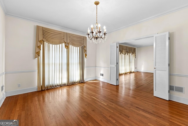 9095 Cedar Grove Rd, Fairburn, GA 30213 - spare room with visible vents, hardwood / wood-style flooring, ornamental molding, and a chandelier