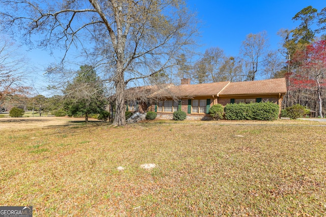 9095 Cedar Grove Rd, Fairburn, GA 30213 - ranch-style home with a chimney, a front yard, covered porch, and brick siding