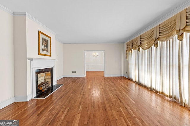 9095 Cedar Grove Rd, Fairburn, GA 30213 - unfurnished living room with ornamental molding, a fireplace with raised hearth, baseboards, visible vents, and light wood-style flooring