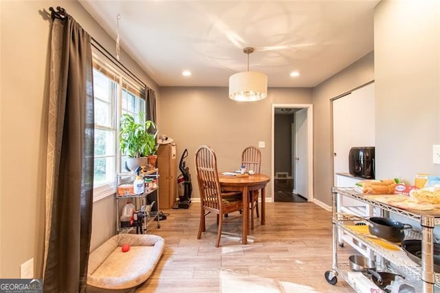 dining room featuring baseboards, light wood finished floors, and recessed lighting