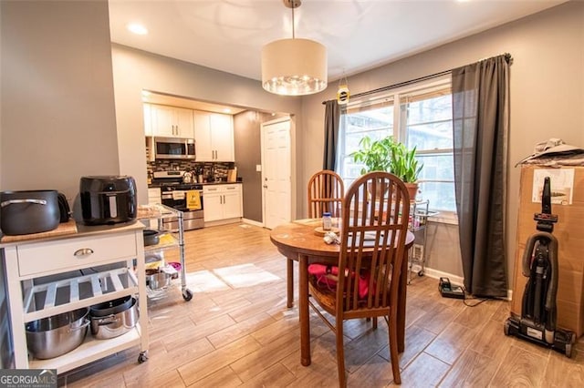 dining room with baseboards and light wood-type flooring