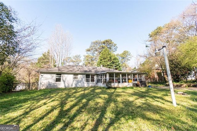 back of house featuring a lawn and a sunroom