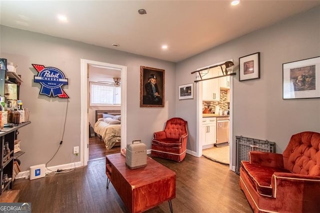 sitting room with baseboards, wood finished floors, and recessed lighting
