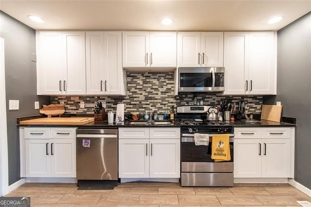 kitchen featuring white cabinets, wood finish floors, stainless steel appliances, and tasteful backsplash