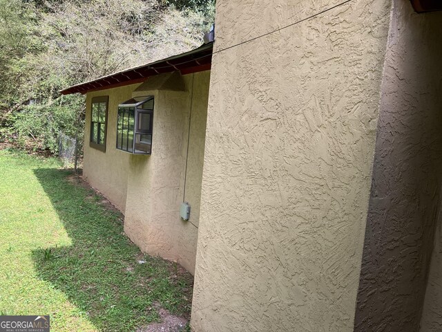 view of home's exterior with a lawn and stucco siding