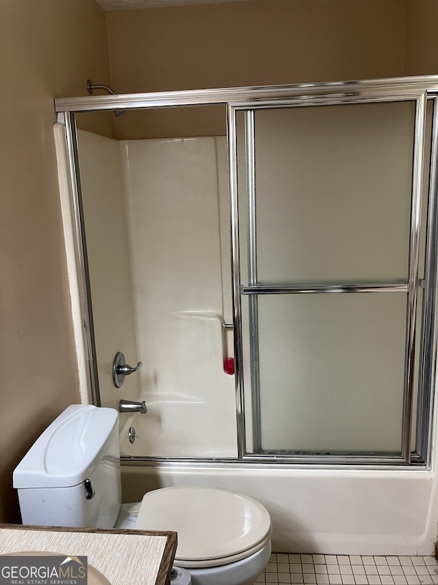 full bath with tile patterned flooring, enclosed tub / shower combo, vanity, and toilet