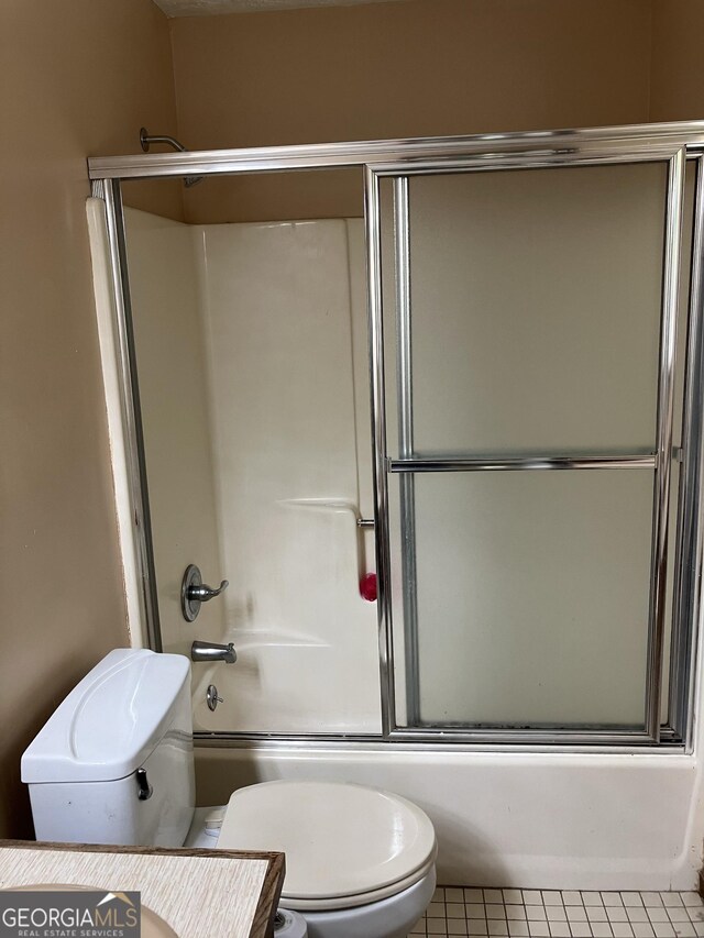 1288 Lakewood Dr NE, Conyers, GA 30013 - full bathroom with shower / bath combination with glass door, tile patterned flooring, and toilet