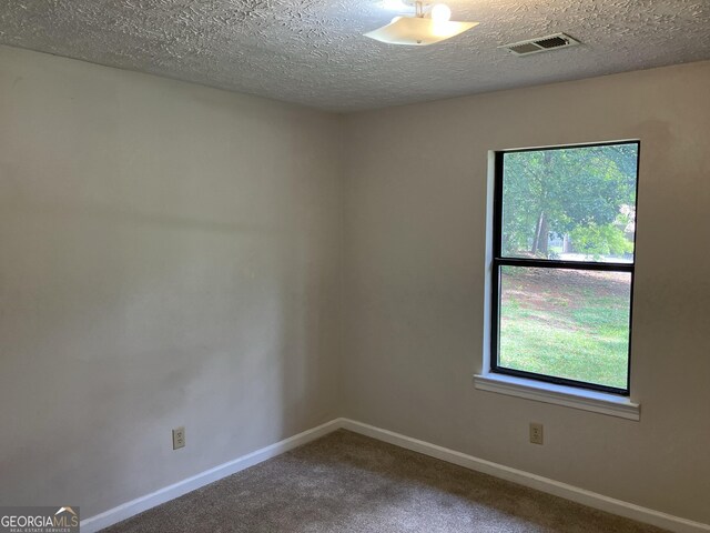 1288 Lakewood Dr NE, Conyers, GA 30013 - spare room with carpet floors, a textured ceiling, visible vents, and baseboards