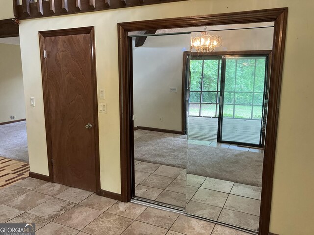 1288 Lakewood Dr NE, Conyers, GA 30013 - interior space with baseboards, a notable chandelier, light carpet, and light tile patterned floors