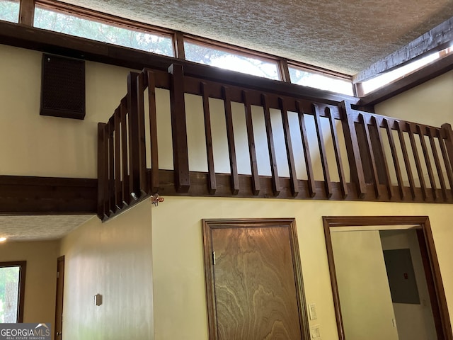 staircase with a textured ceiling