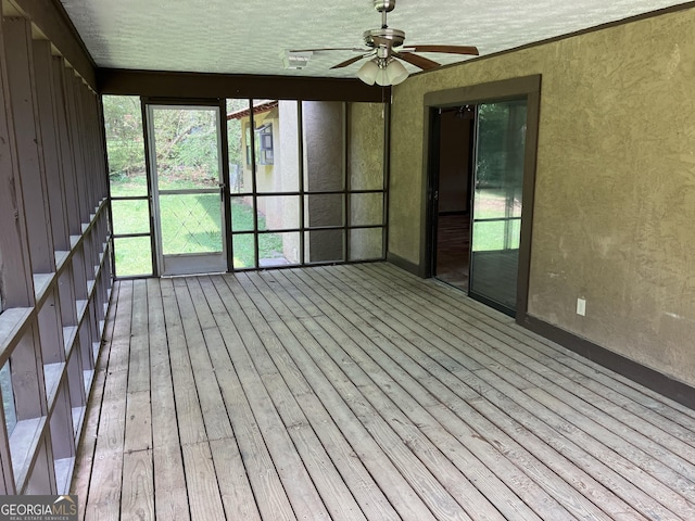 unfurnished sunroom with a ceiling fan