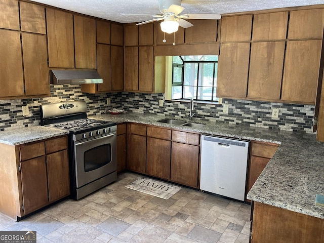 kitchen with decorative backsplash, a ceiling fan, range hood, a sink, and stainless steel appliances