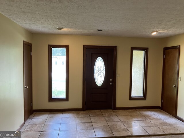 1288 Lakewood Dr NE, Conyers, GA 30013 - entryway featuring baseboards, light tile patterned flooring, a textured ceiling, and visible vents