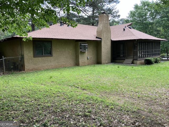 back of house with roof with shingles, fence, stucco siding, a sunroom, and a chimney