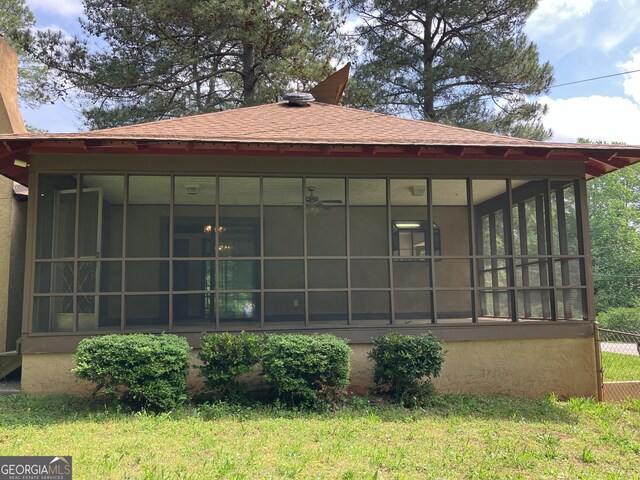 rear view of property with a sunroom and stucco siding