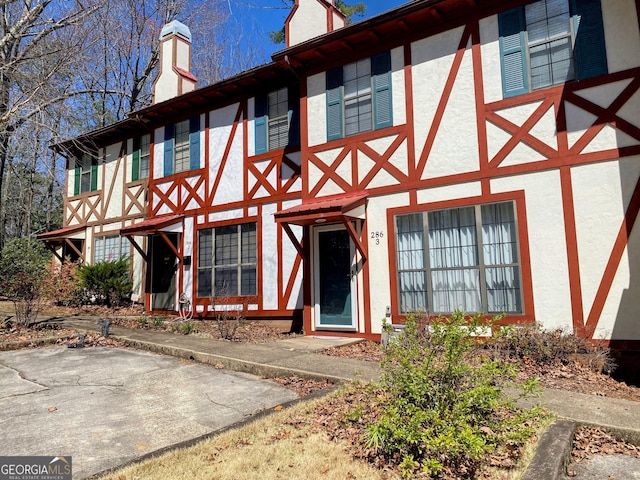 view of front facade with stucco siding and a chimney