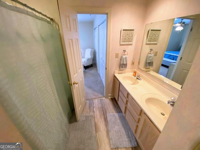 ensuite bathroom featuring double vanity, a sink, connected bathroom, and ceiling fan