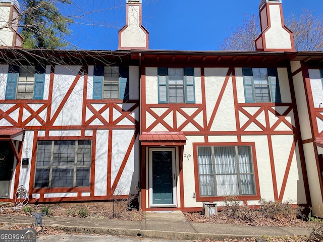 view of front of house featuring stucco siding and a chimney