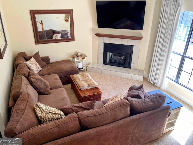 carpeted living room with plenty of natural light, a tile fireplace, and baseboards