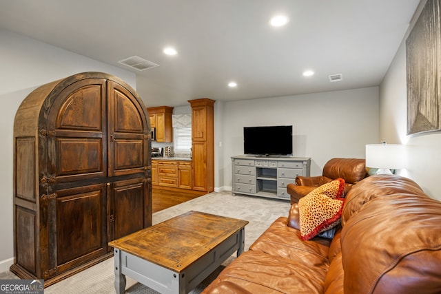 living area with visible vents, recessed lighting, and light colored carpet