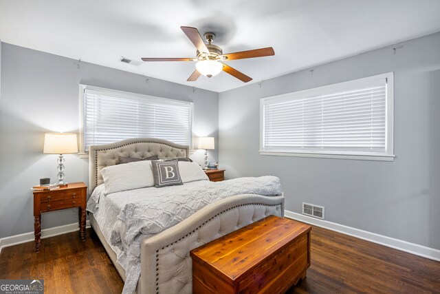 bedroom with baseboards, visible vents, and wood finished floors