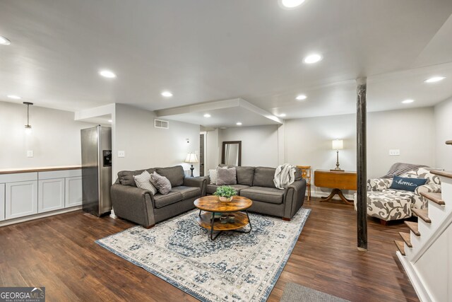 living room with recessed lighting, dark wood-type flooring, and visible vents