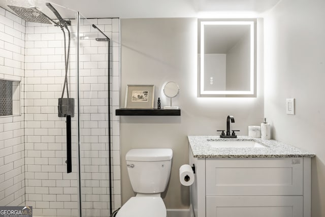 bathroom with a stall shower, toilet, and vanity