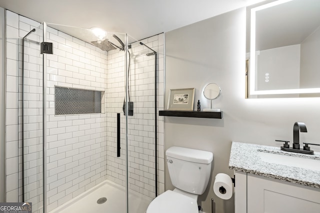 bathroom with vanity, toilet, and a shower stall