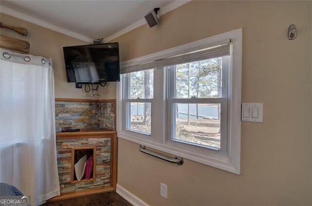 living room featuring healthy amount of natural light, ornamental molding, wood finished floors, and baseboards
