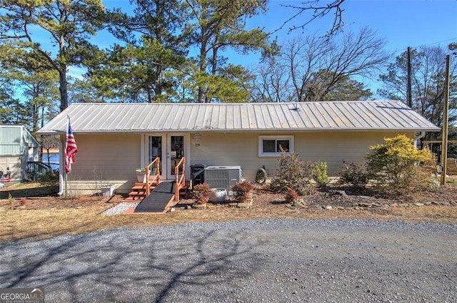 view of front of property featuring central air condition unit and metal roof