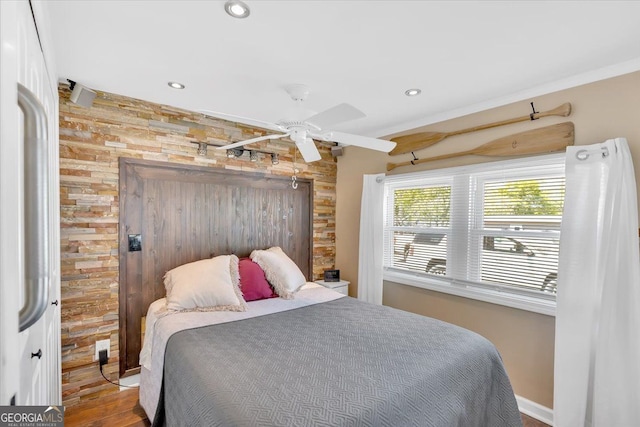 bedroom with wood finished floors, recessed lighting, ceiling fan, baseboards, and wooden walls