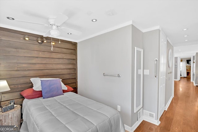 bedroom featuring wood finished floors, recessed lighting, baseboards, ornamental molding, and a ceiling fan
