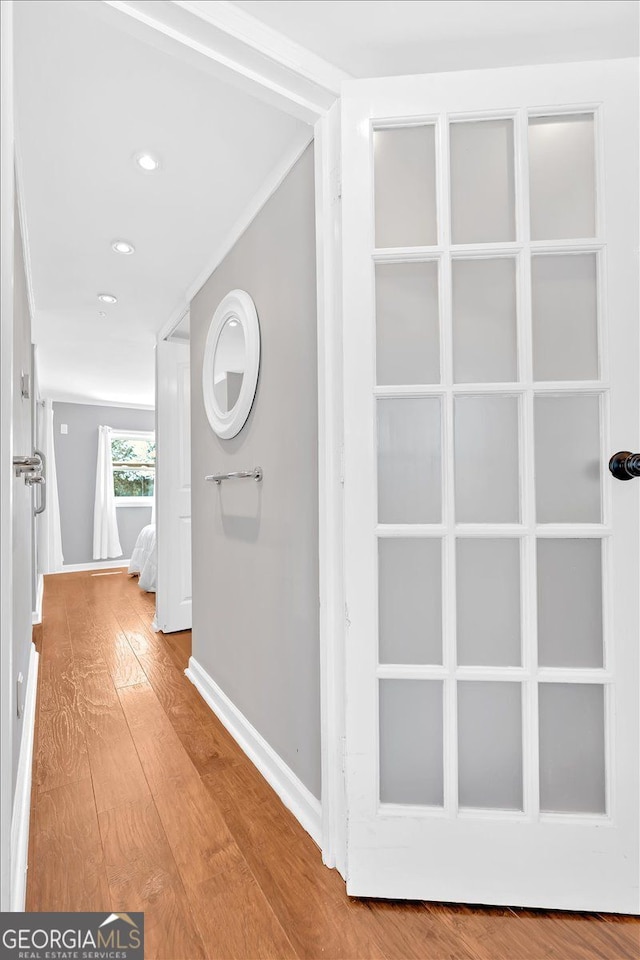 hallway with hardwood / wood-style floors, baseboards, and recessed lighting