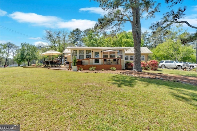 view of front of property featuring a front yard and a sunroom