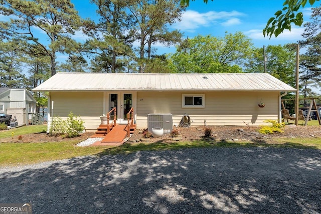 back of house featuring metal roof, cooling unit, and french doors