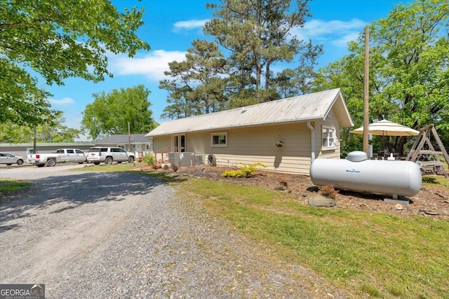 view of side of property featuring metal roof and driveway