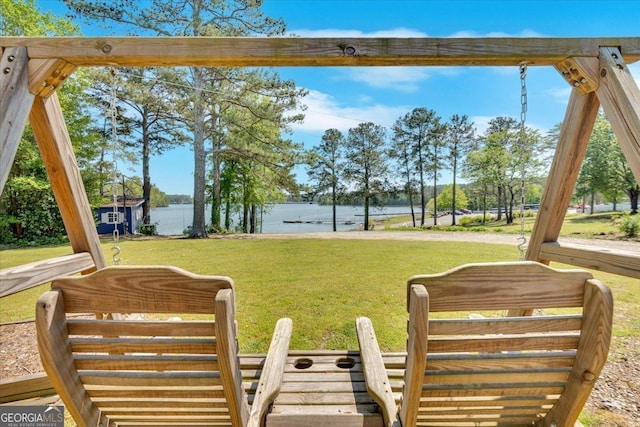 view of green lawn with a water view