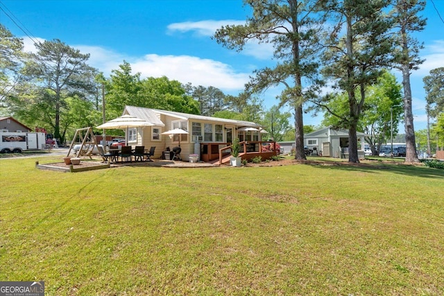 rear view of property featuring a yard and a sunroom