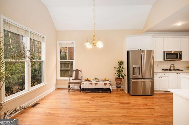 4236 Providence Ln, Tucker, GA 30084 - dining room with visible vents, a chandelier, baseboards, light wood-style floors, and vaulted ceiling