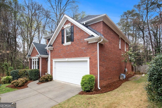 4236 Providence Ln, Tucker, GA 30084 - view of property exterior with driveway, an attached garage, brick siding, and roof with shingles