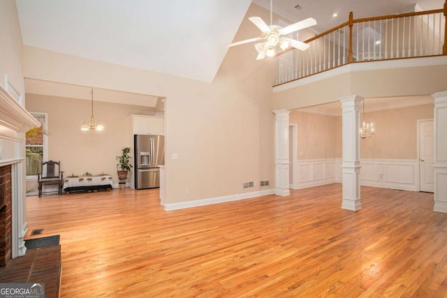 4236 Providence Ln, Tucker, GA 30084 - living room with ceiling fan with notable chandelier, a high ceiling, visible vents, light wood-style flooring, and a fireplace