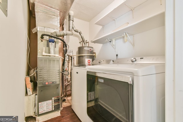 laundry area featuring water heater, washer and clothes dryer, a textured ceiling, dark wood-style floors, and laundry area
