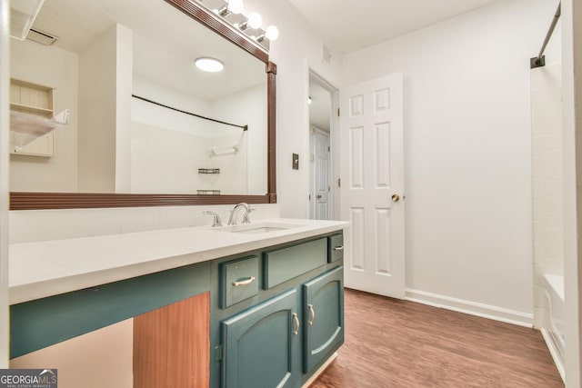 bathroom with vanity, shower / bath combination, baseboards, visible vents, and wood finished floors