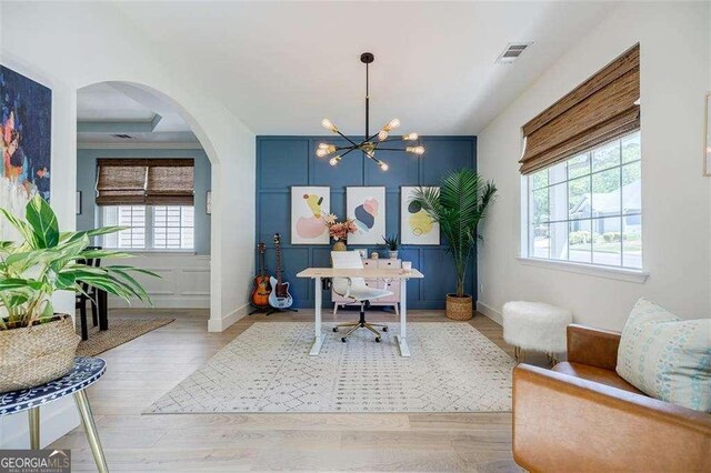 office with visible vents, baseboards, wood finished floors, arched walkways, and an inviting chandelier