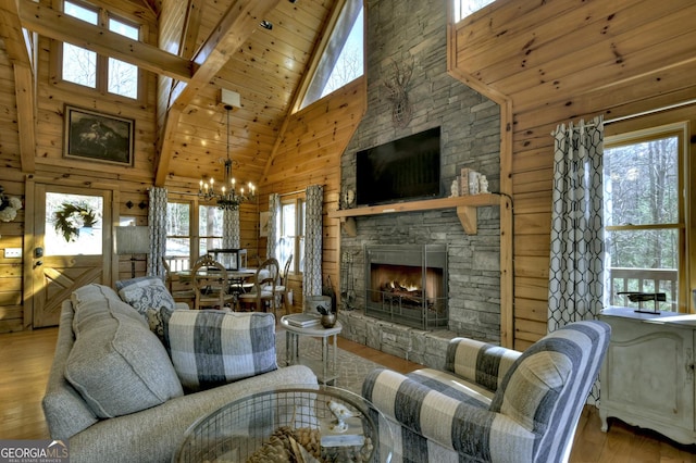 living area with wood walls, wood finished floors, an inviting chandelier, a stone fireplace, and vaulted ceiling