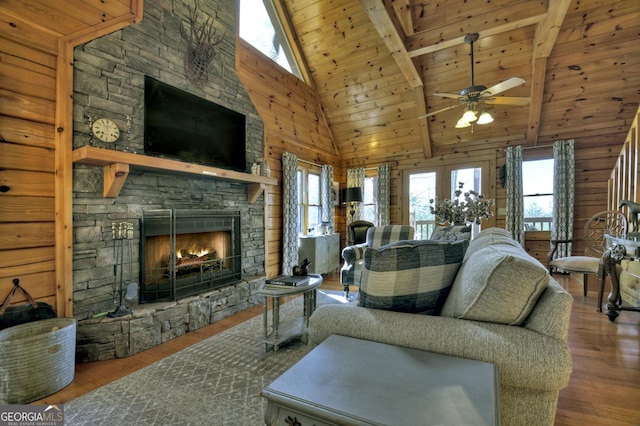 living room with wood finished floors, plenty of natural light, wood ceiling, and a stone fireplace