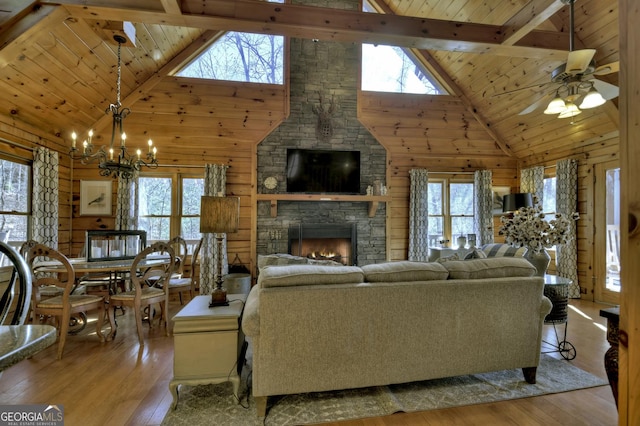 living area featuring hardwood / wood-style floors, wooden ceiling, wood walls, and a stone fireplace