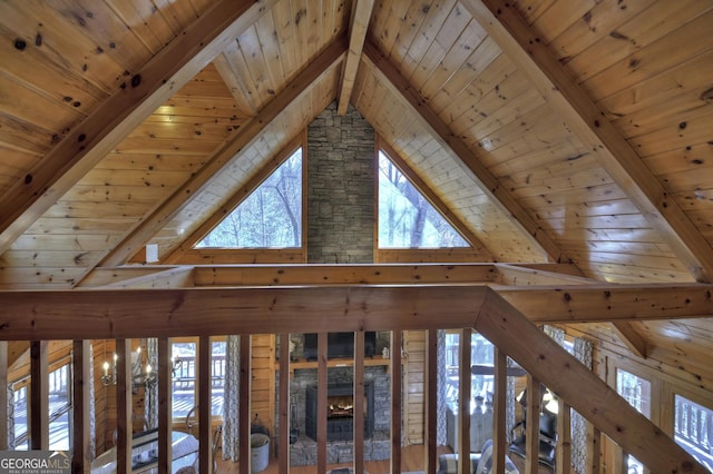 interior details with wood ceiling, a stone fireplace, and beamed ceiling